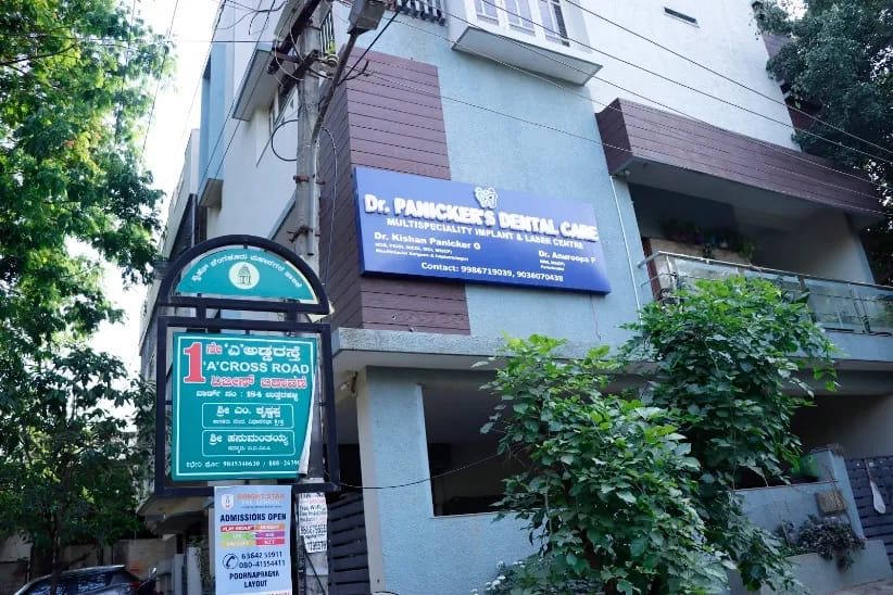 Dr Panicker's Dental Care signboard on the clinic building in AGS Layout